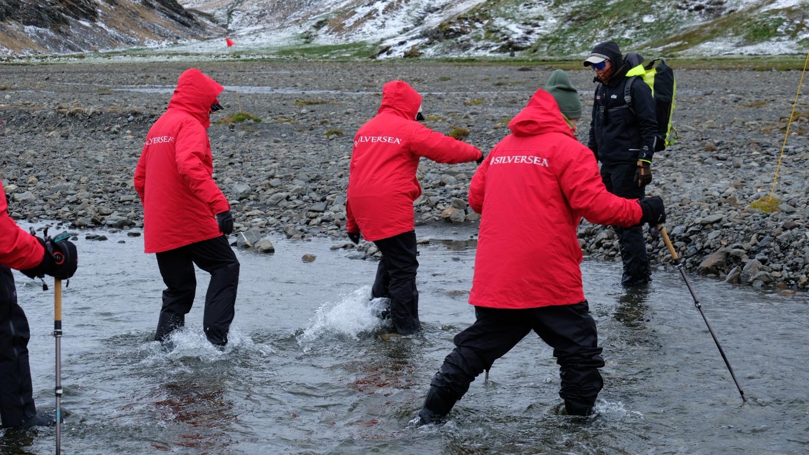 Silversea expedition guides in red parkas preparing a shore landing in Antarctica
